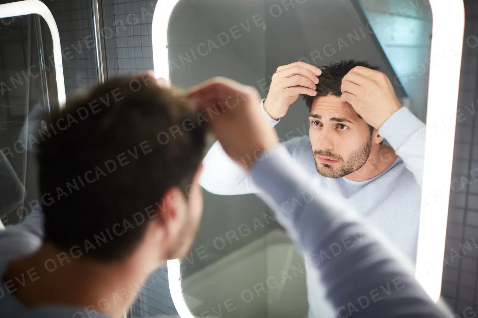 Mann untersucht Haarausfall im Spiegel